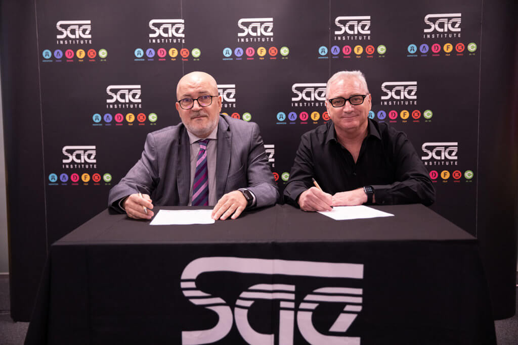 Two men sitting and signing a contract