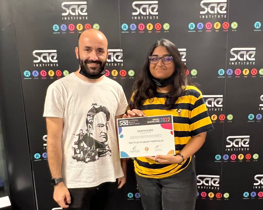 a student standing with an industry expert with a certificate